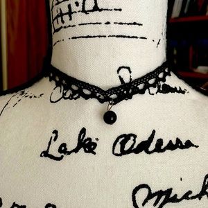 Lace choker with black bead.